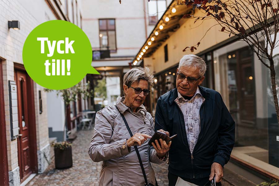 Två personer tittar på en telefon.