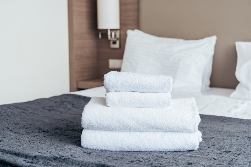 2704 32583505 folded white towels on bed in hotel room