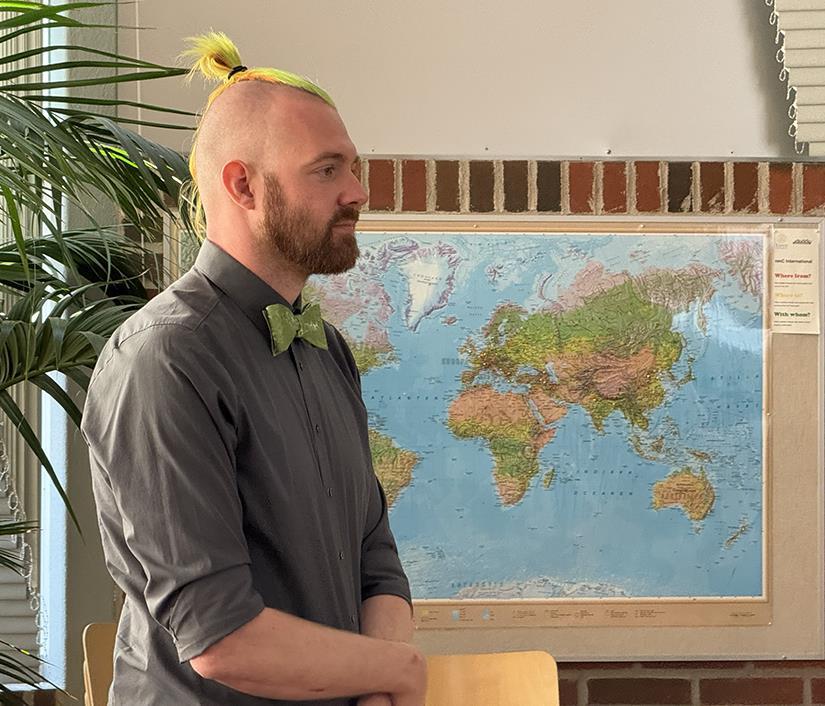 Photo of a man in grey shirt and green fly.
