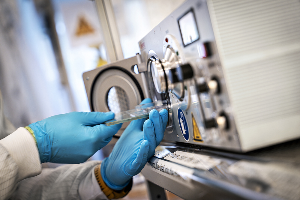 Photo of hands working scientific device.