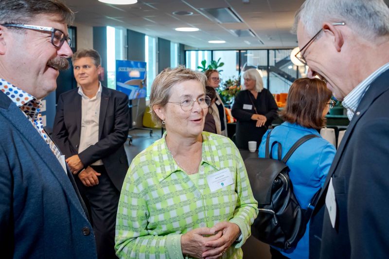 Photo of three people talking.