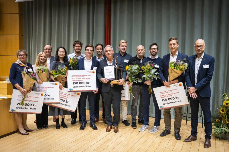 Photo of people with diplomas and flowers.