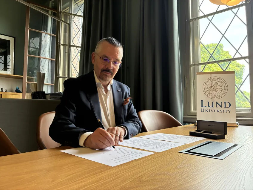 A man signing a document. Photo.