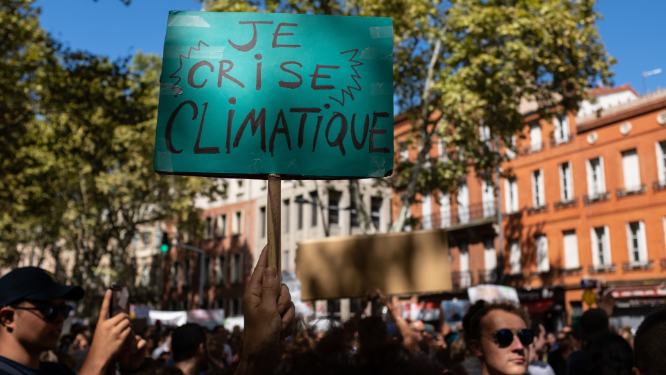 Foto på människor som protesterar mot klimatförändringarna.