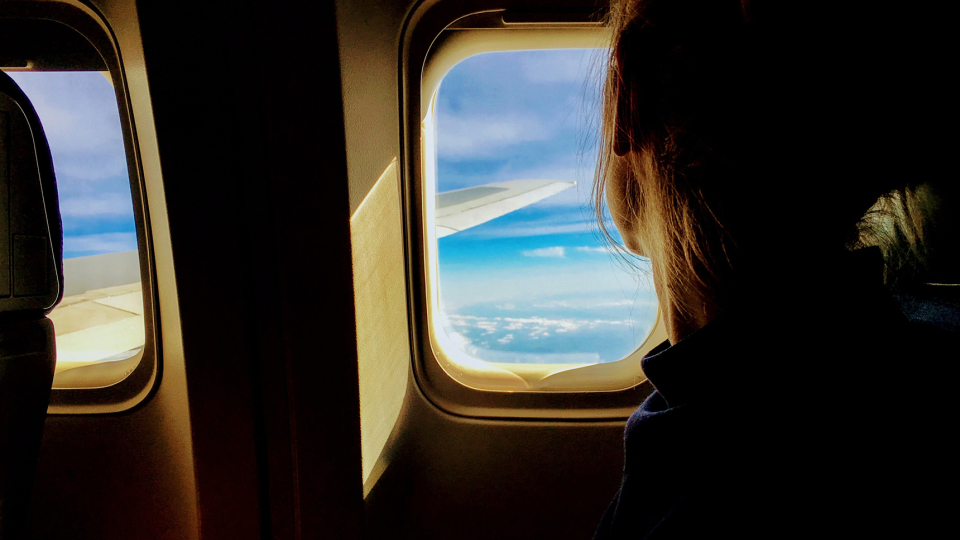 Person tittar ut ur flygplansfönster. Foto: Tim Gouw/Unsplash