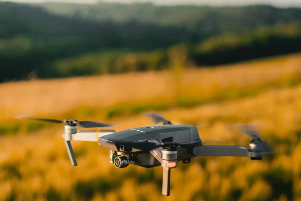 Drönare flyger över ett fält. Foto: Gautier Salles, Unsplash.