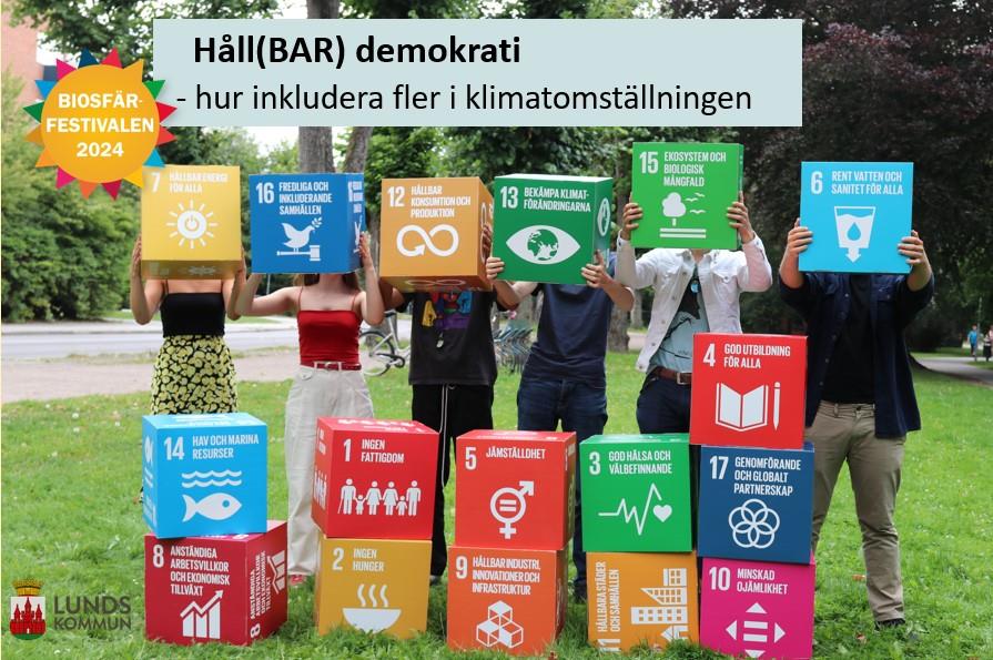 Personer som håller upp kuber med globala målen. Foto. 