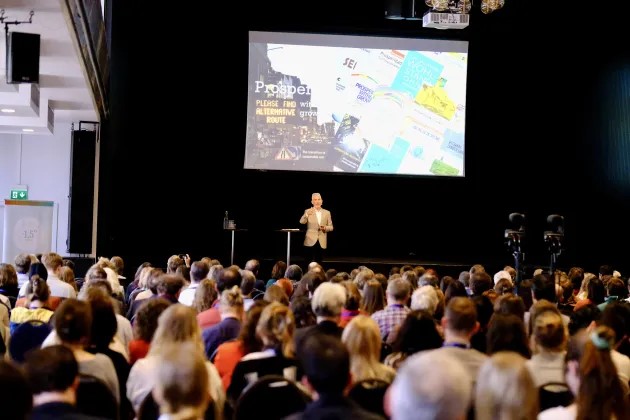 En stor publik framför en scen med en Tv-skärm och en talare. Fotograf Håkan Rodhe.