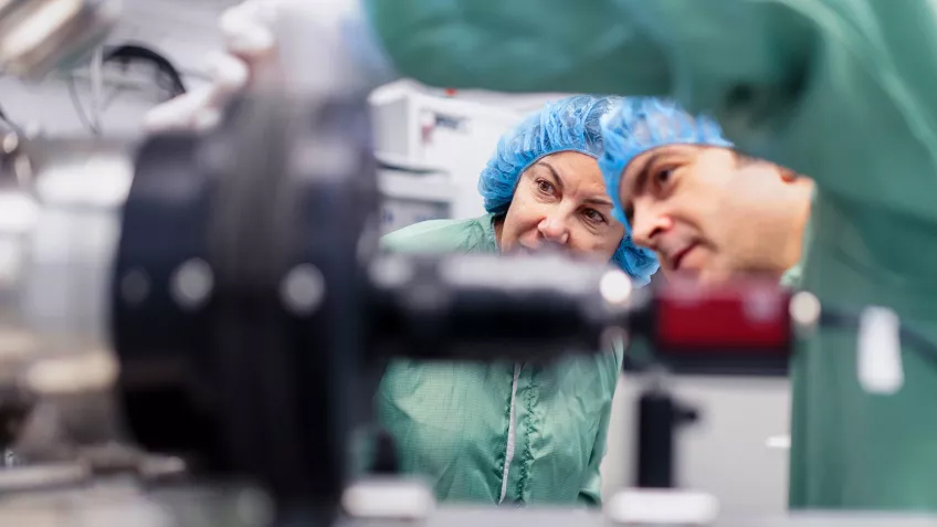 Photo of two people managing scientific equipment.