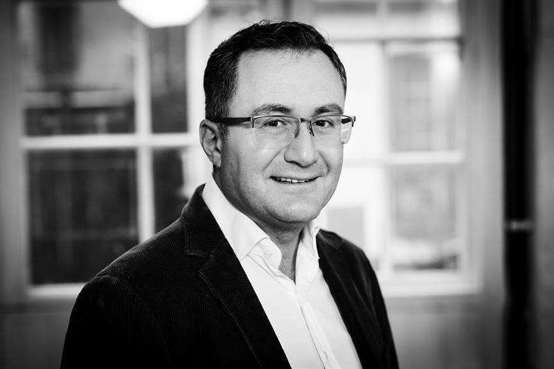 Black and white photo of a man in glasses.