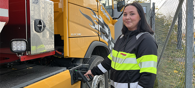 Ida står och laddar el-schaktbilen.