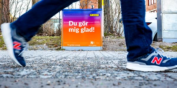 Nacka Energi kabelskåp med budskapet "Du gör mig glad" i fokus.