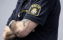 Bild av polisarm i t-skjorta med texten polis.