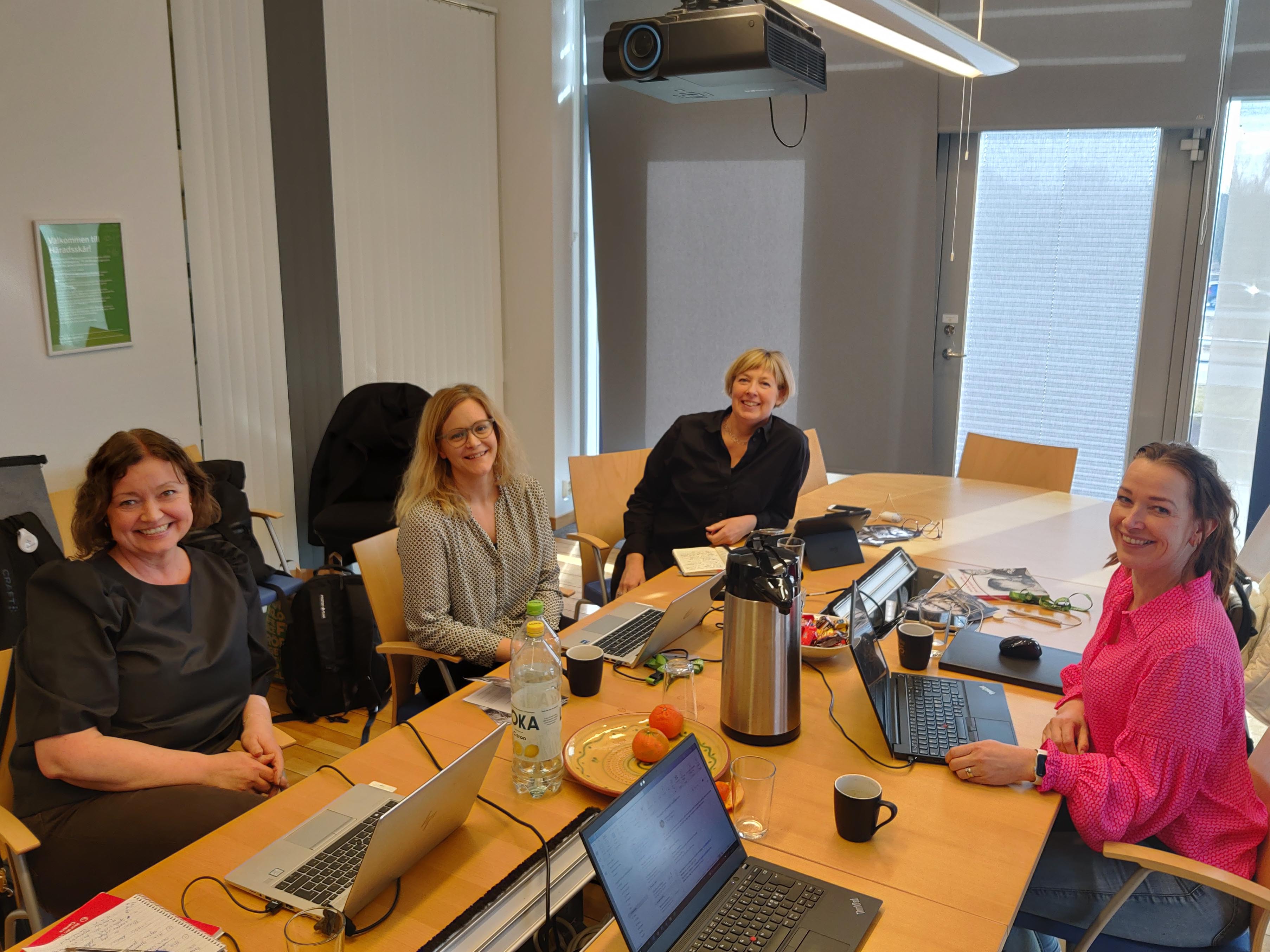 Bild på fyra kvinnor som sitter runt ett bord med varsin dator
