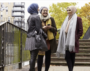 Three young muslim women talking and laughing.