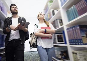 Young man and woman surrounded by books