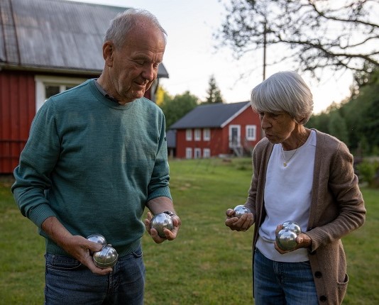 Äldre man och kvinna spelar boule