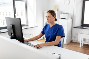 Sjukskötare sitter framför en datorskärm