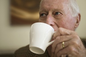 Äldre man dricker kaffe.