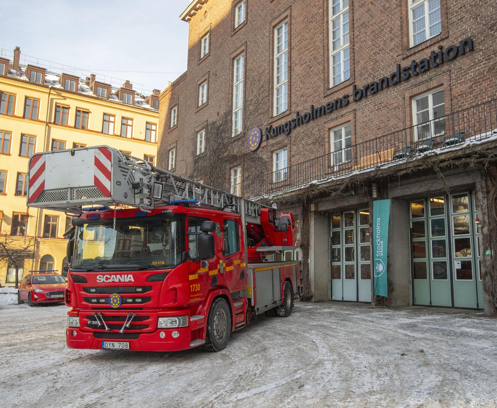 Framsidan av brandstationen med dess karaktäristiska tegelfasad och stora portar för brandbilarna, foto.