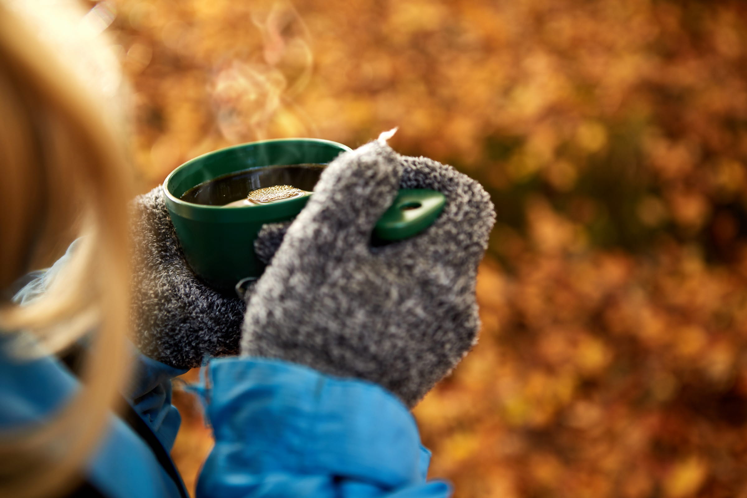 542 Woman wearing mittens holding a smoking hot cup of